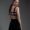 Woman standing in black set looking back at camera